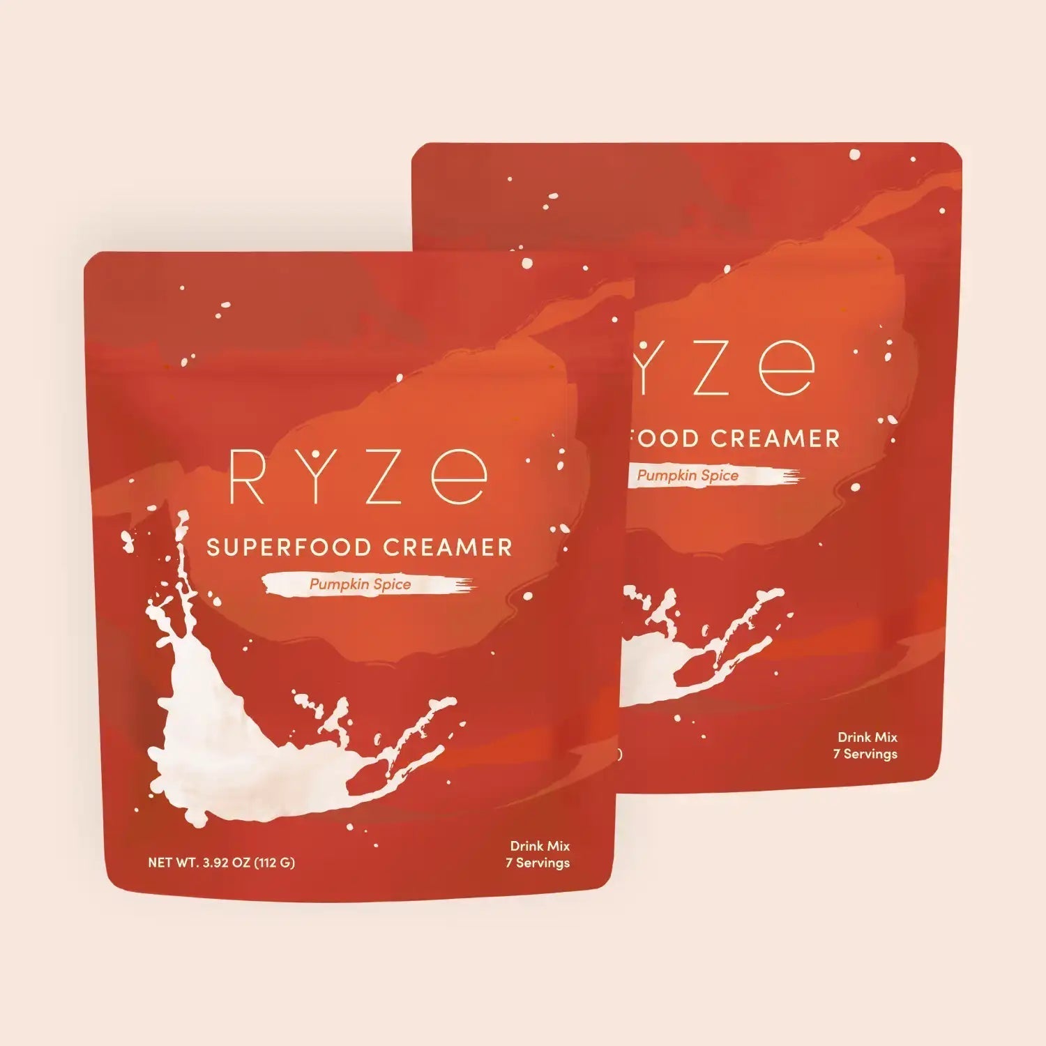 RYZE pumpkin spice superfood creamer packets with milk splash on orange-red background